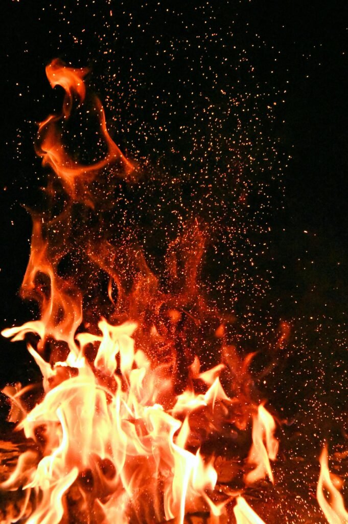 pexels-photo-1558916-1558916 Vivid orange flames and sparks dance against a mysterious black backdrop.